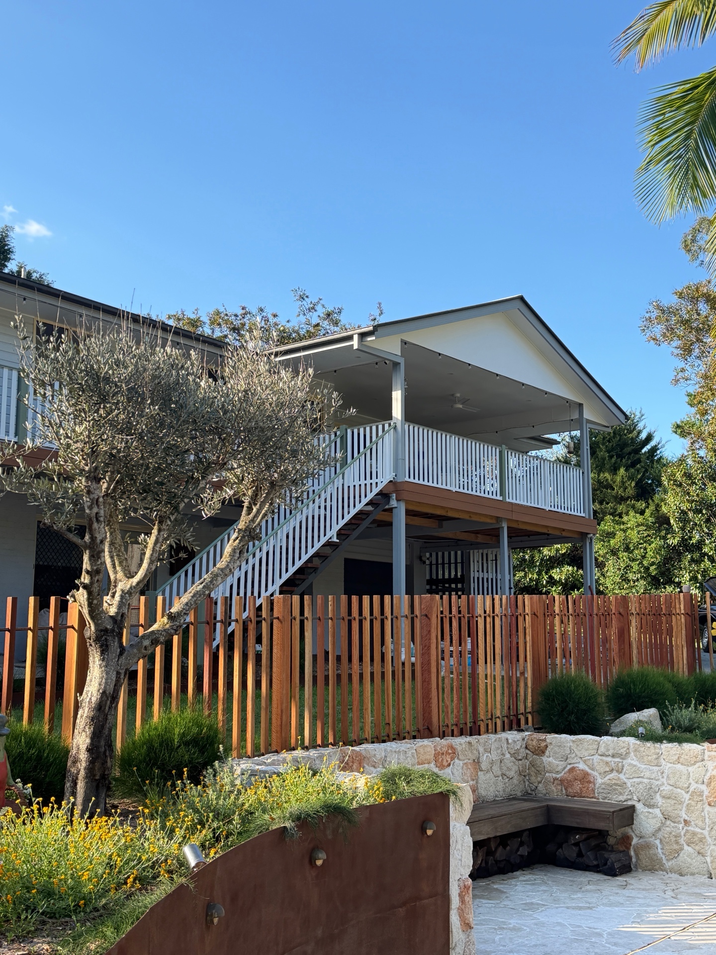Front garden detail — olive tree planting, timber screening, stone seating and corten edging.
