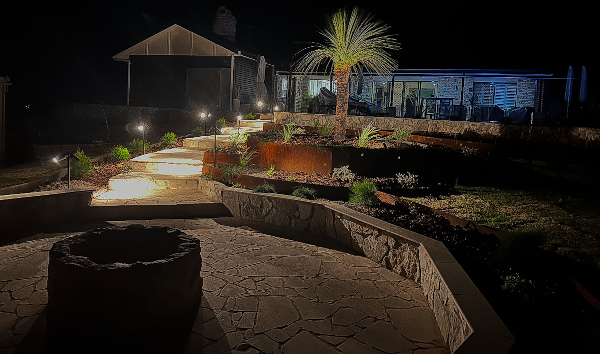 AP Constructions Gold Coast landscape project with illuminated garden pathway, corten steel edging and feature planting at dusk