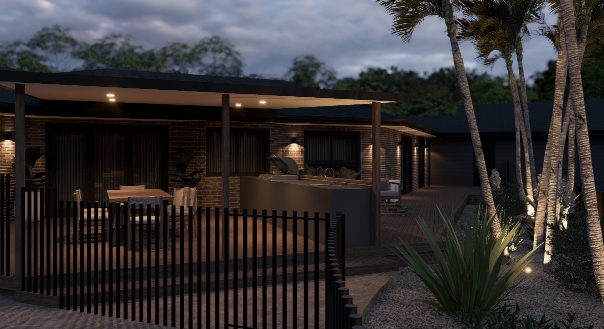 Evening exterior — alfresco lighting, outdoor kitchen, feature wall lights and palm uplighting.